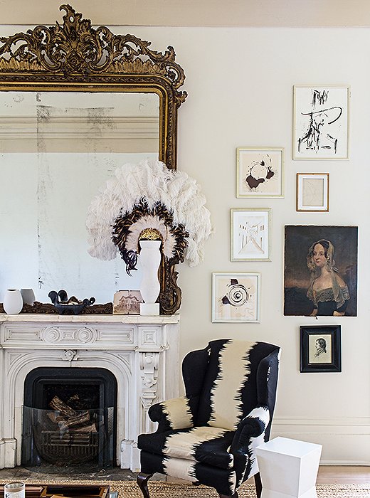 Sara kept the massive ornate mirror that came with the house and hung artwork—including spin art by designer Miles Redd and an old family portrait—floor to ceiling to help fill the incredibly high walls.
