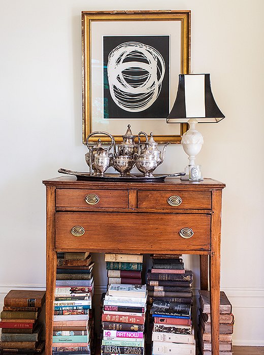 An Early American huntboard offers a simple handsomeness plus storage space for cards and poker chips. A traditionalist might have filled the space beneath it with an urn; Sara chose books.
