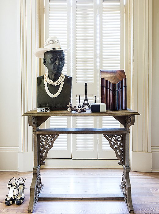 In a bedroom antechamber, a table by Thomas O’Brien displays a vintage knife holder (now used to store letters) and, adding a little levity, a vintage bust decked out in a hat and pearls. “I just have a thing for busts. When you’re lonely it’s like having some friends in the house.”

