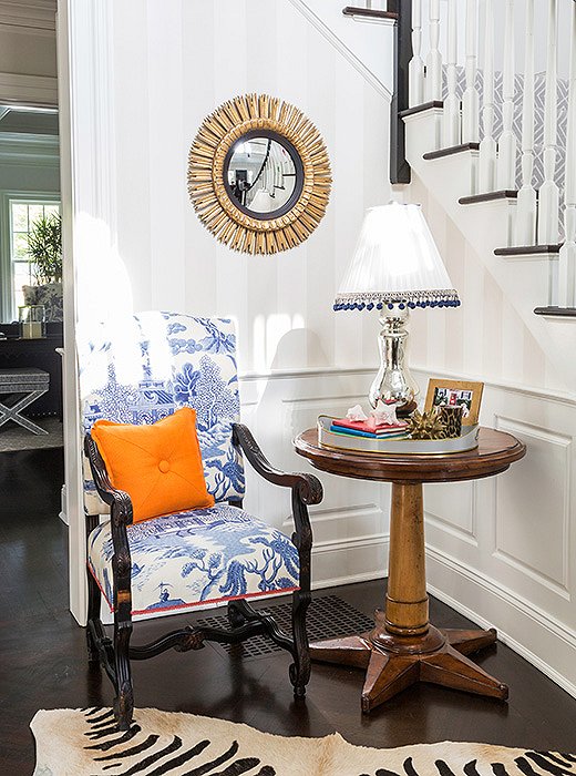 A toile-upholstered chair feels fresh when paired with a zebra rug.
