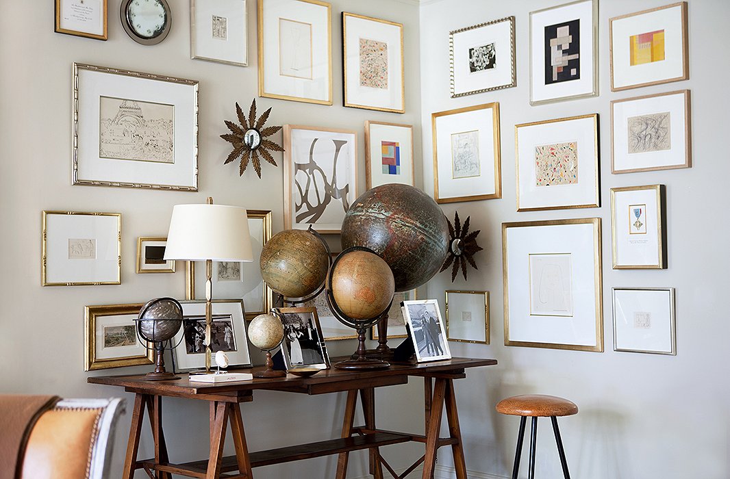 An ever-expanding gallery wall fills a corner above Suzanne’s collection of vintage globes. “I hang the frames in a random pattern because I’m always adding to it! A constant theme has been collecting art and then finding enough walls to hang it on.”

