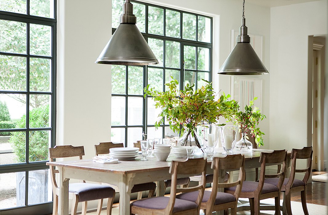 Sunlight pours into the breakfast area through steel casement windows; their industrial feel is carried through to the pewter pendant lights.

