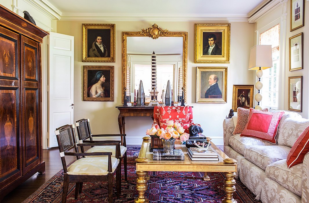 Many of Timothy’s fabrics (including those on the red chair, the pillows, the lampshade, and the drapes) are on display in the family room, where Timothy and his partner, Kathleen Scheinfeld, watch TV (hidden from view in the cabinet).

