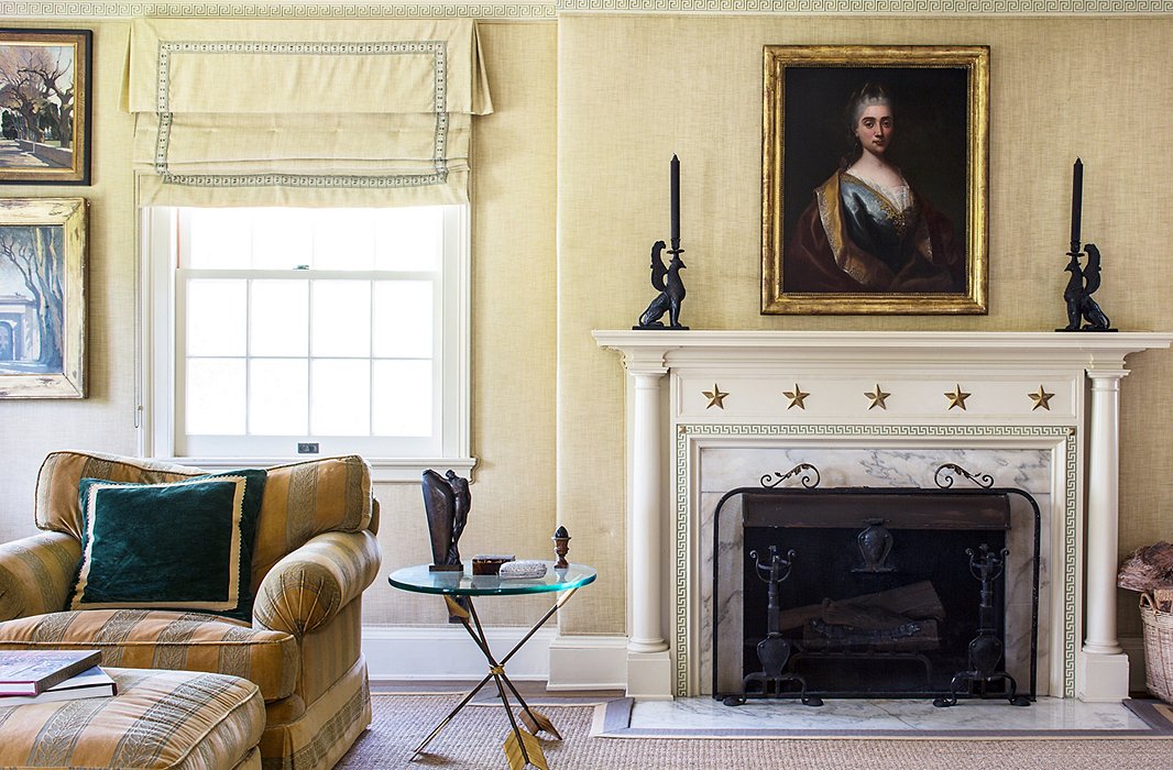 Timothy and Kathleen have coffee and read the newspaper in the master bedroom’s comfortable seating area, done mostly in golds and greens; the end table is from Timothy Corrigan Home.
