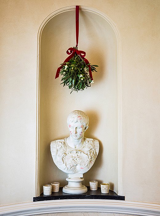 Caesar, the household dandy, stands guard in the hallway under the mistletoe. The lipstick marks are from Alessandra’s godchildren; she eventually varnished the bust to officially seal all their kisses.
