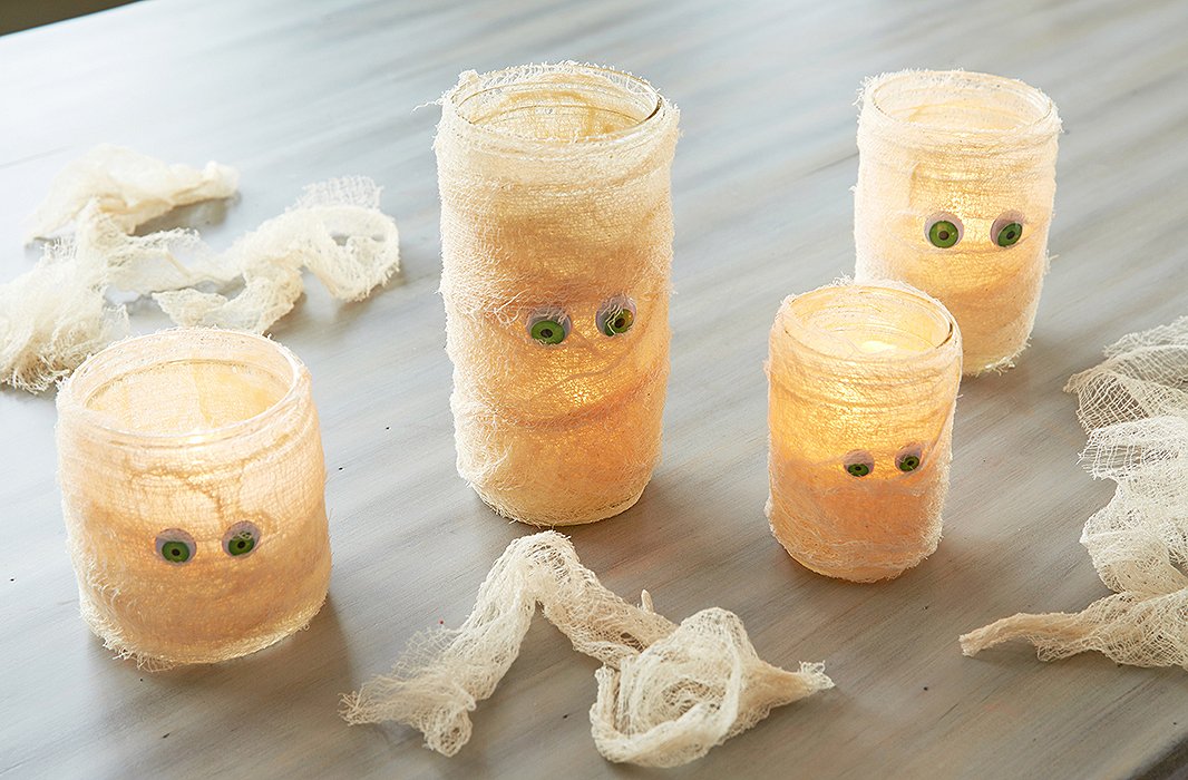 Cheesecloth-wrapped mason-jar candles make for dim mood lighting while serving double-duty as adorable mummies.
