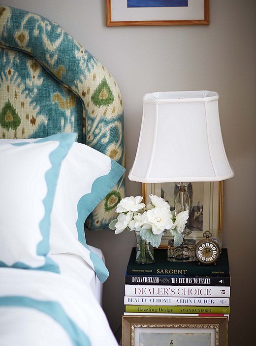 Fresh flowers add a note of polish to the bedside tables, which are made up of giant stacks of beautiful books.
