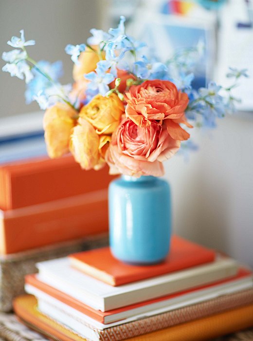 Rather than strictly color-coordinate, Heather layers the colors of her books to add depth and contrast—as in this deskside vignette.
