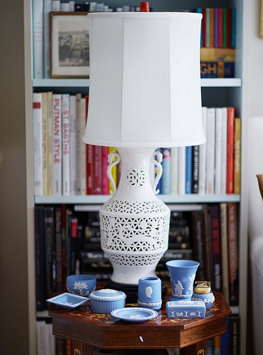 A collection of Wedgwood sits with a blanc de chine lamp.
