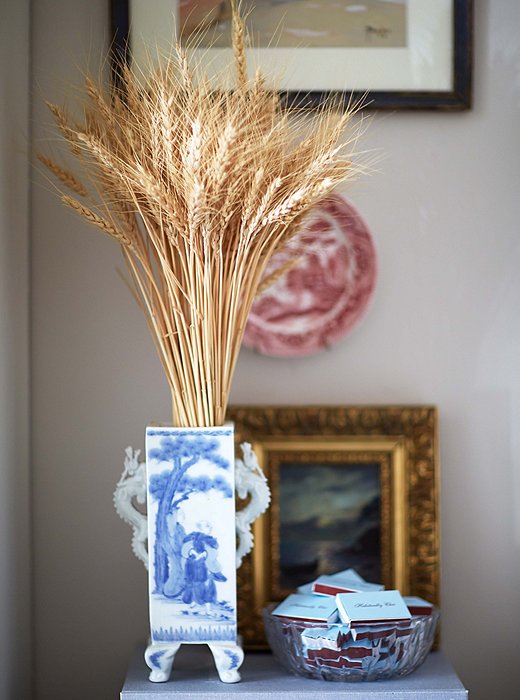 Wheat brings a natural note to a chinoiserie vase and balances the more ornate gilt frame and intricately painted plate.
