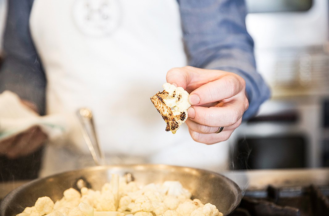 A cauliflower floret browns in the pan before it heads to the over to roast.
