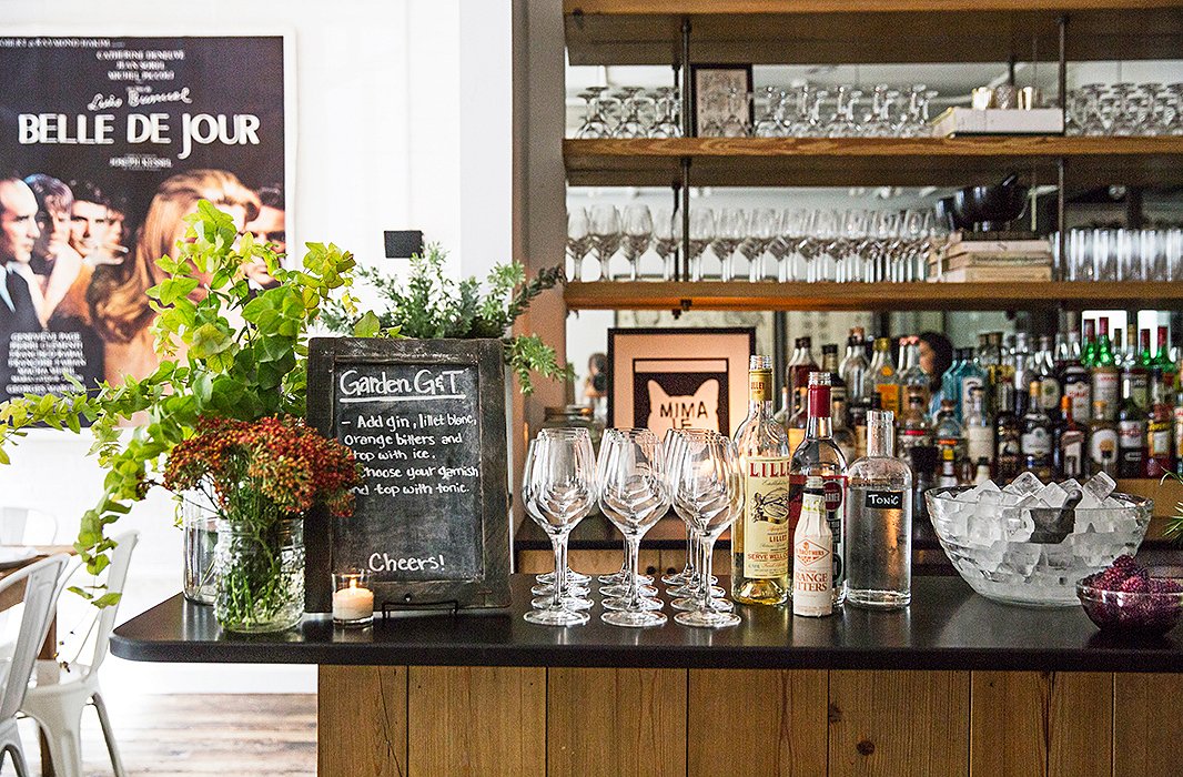 A chalkboard sign tells guests the easy steps to making their own Garden Gin and Tonic: “Add gin, Lillet Blanc, orange bitters, and top with ice. Choose your garnish and top with tonic.”
