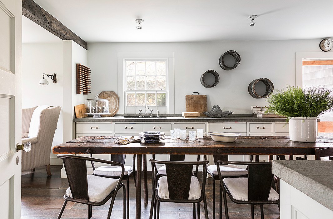 The weathered wood table in designer James Huniford’s kitchen reiterates the texture of the wide-plank floors and provides an organic contrast to the industrial steel chairs. Photo by Lesley Unruh.
