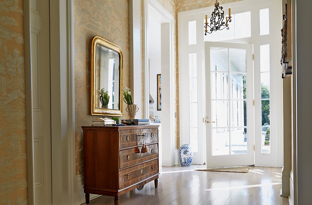  In the foyer just outside the dining room, a chest keeps candles, napkin rings, and other tabletop accessories within easy reach.

