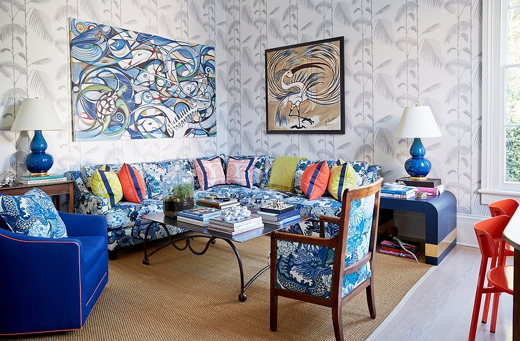 The den features artwork by her friend Alex Beard atop Cole & Son’s Palm wallpaper.
