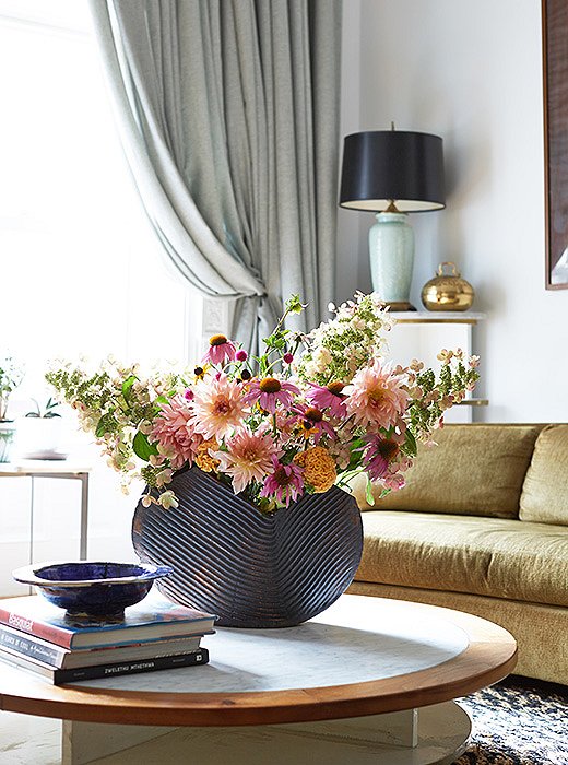 Lively pink echinaceas, mums, and pink dogwood branches create a striking contrast to a heavy ceramic vessel. Photo by Manuel Rodriguez.
