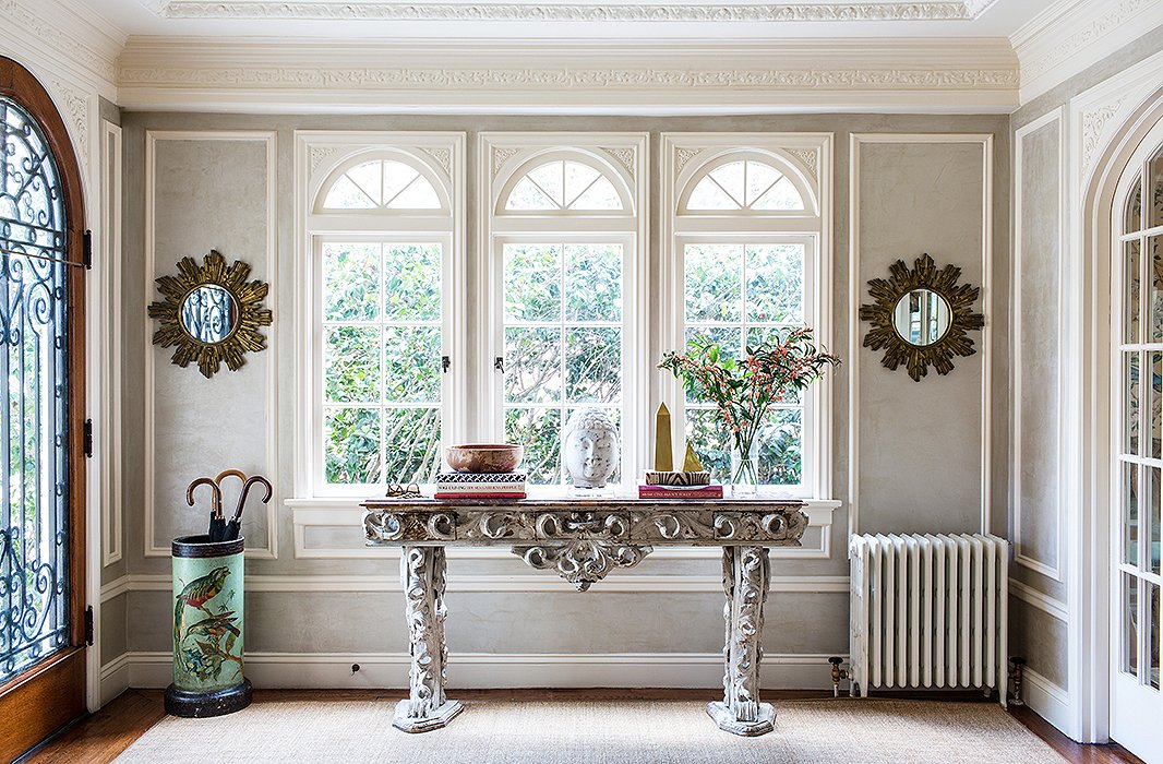 Frame a wide set of windows with a pair of small sunburst mirrors to create well-rounded symmetry. Photo by Nicole LaMotte.
