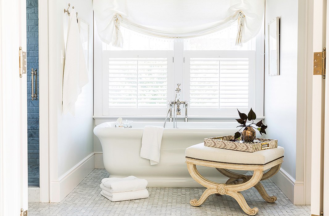 An antique bench brings a second neutral shade—a soft cream—to the bathtub zone.

