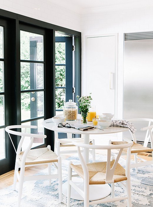 The breakfast table sits on one end of the kitchen, where French doors open out to an English garden.
