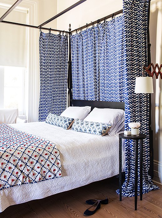 In a bedroom of bold blue patterns, a white quilted coverlet provides restful simplicity. Photo by Nicole LaMotte.
