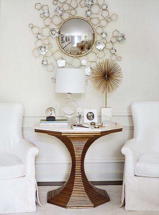 Repeated curves—in the round mirror, the pedestal table, the sputnik sculpture, and the lamp—give this bedroom seating area an interesting visual rhythm.
 
 
