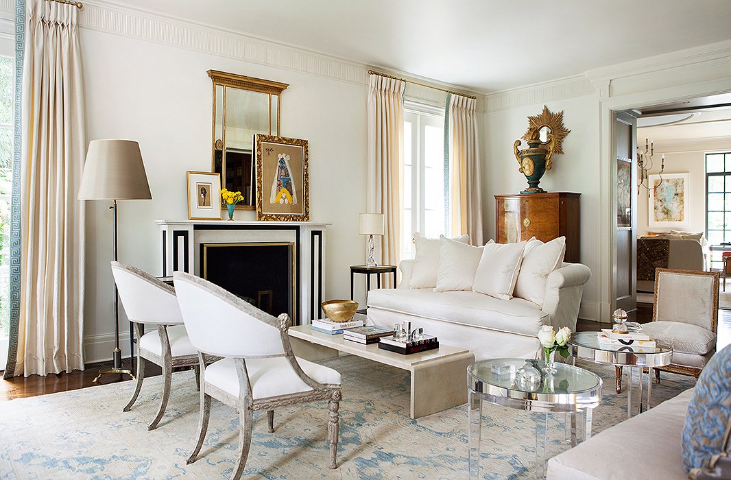 Throughout the home, a restrained palette unifies a mix of styles and eras. Lucite tables, antique Swedish chairs, and a French Moderne-style coffee table form an asymmetrical yet balanced arrangement in the living room.
