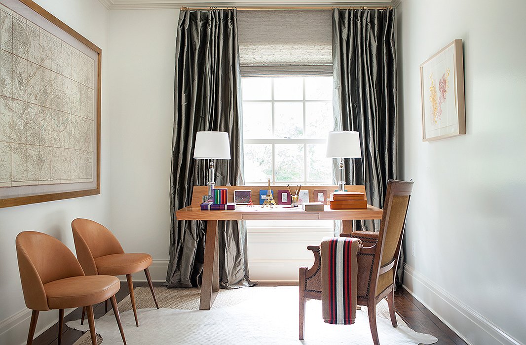 Illustrating her flair for mixing styles, Suzanne combined a sleek, modern desk, a French-style armchair, and a hide rug in a <a href=