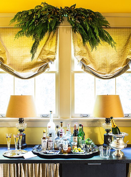 This elegant bar is given just enough holiday flair courtesy of the greenery-dressed curtain.
