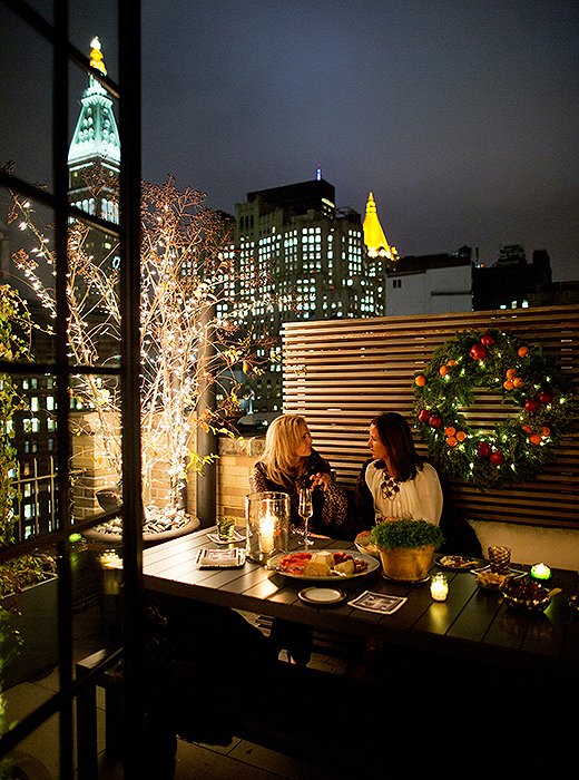 Guests cozy up with throw blankets as they chat on the terrace amid stunning views of the Manhattan skyline.
