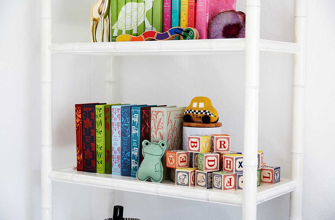 Colorful design classics share shelf space with a set of stacked blocks, brilliantly stored away while doubling as visual appeal.

