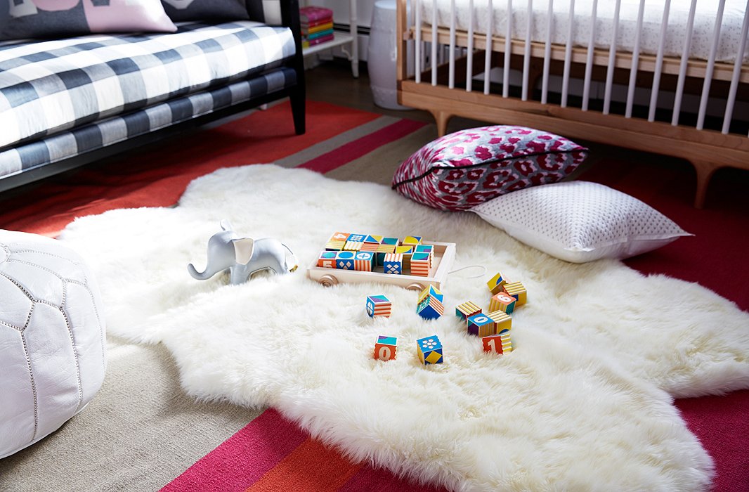 To create a soft, warm feeling, a Mongolian sheepskin, perfect for a bit of tummy time, was layered on top of a burnt-orange-and-fuchsia dhurrie.

