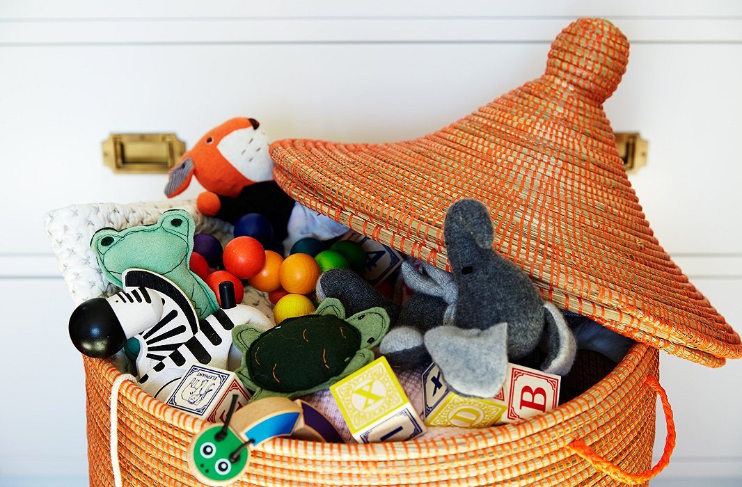 A lidded basket is an ideal spot to keep toys. Once they’re mobile, children can easily get into the basket themselves, and you can quickly declutter a room by tossing all toys and blocks back in the basket.

