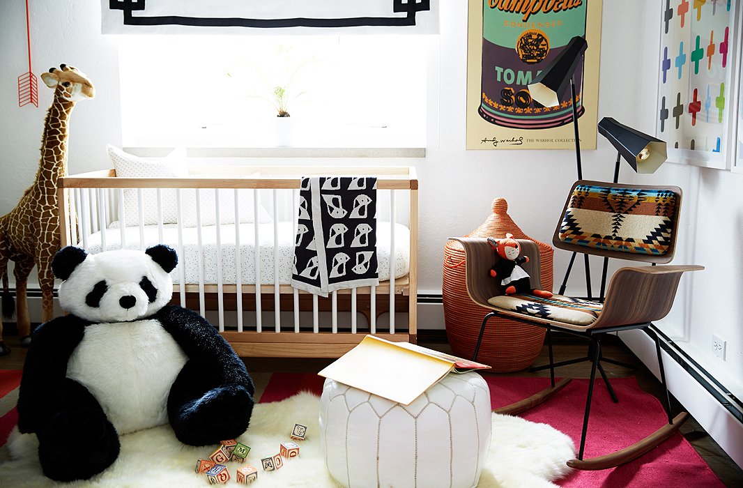 The crib fit perfectly under the window, and a blackout shade backed in white linen was added for nap time. The black-and-white contrasts are played up with a giant panda.
