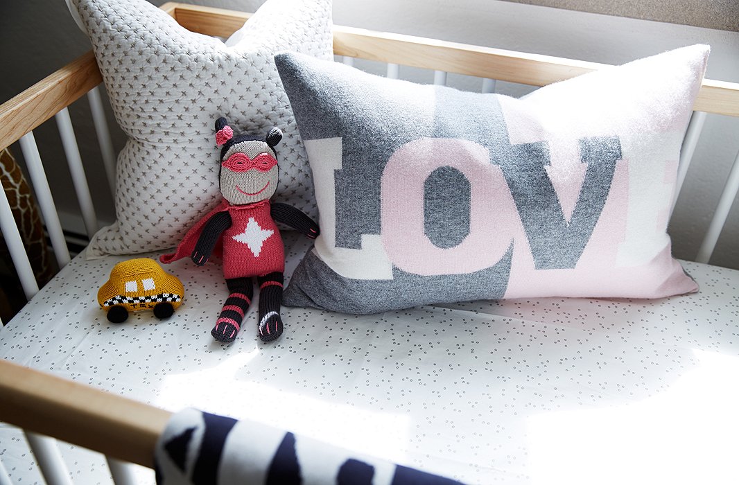 A gray-and-pink graphic pillow picks up on the Pop art in the rest of the house. As for the toys, Coco says she “doesn’t want to get into gender rules so much. I don’t think that cars are only for the boys!”

