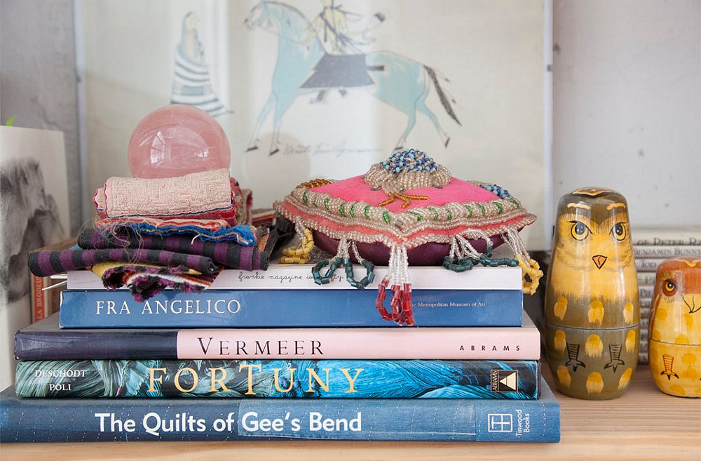 A Native American pincushion and a stack of fabric scraps (one of Housley’s many collections) top a few of her favorite coffee table books. And the owls? A set of nesting dolls from a friend.
