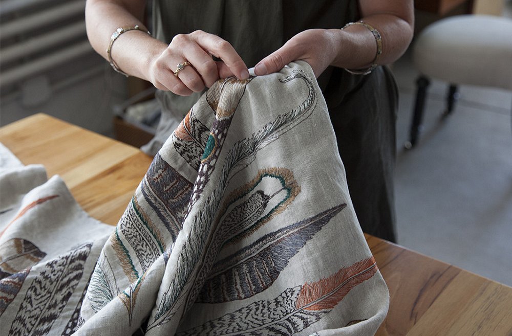 Housley shows off the intricate stitchery on a feather-festooned table runner.
