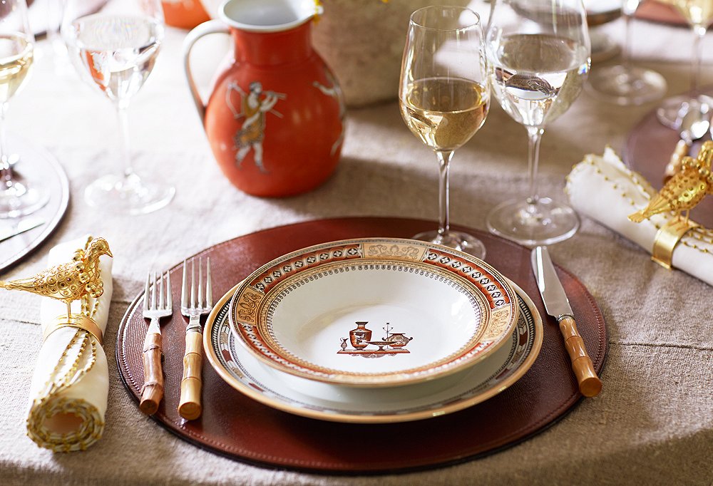 Hits of burnt orange keep this holiday-ready tablescape cohesive. “Color is one of the most unifying ways to pull disparate elements together,” Dransfield says.
