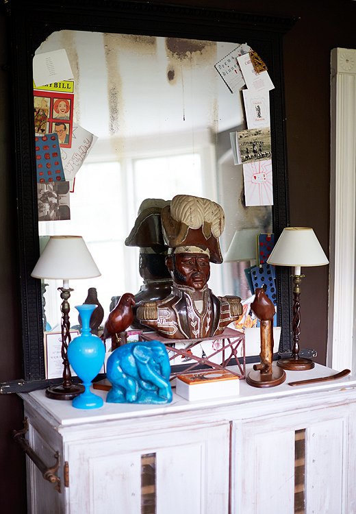 Recent postcards and invites frame the mirror-turned-bulletin board in the study. The pairing of a 1930s elephant from France and the bust of a “rather stern” Haitian general demonstrates the duo’s love of mixing time periods and design styles.
