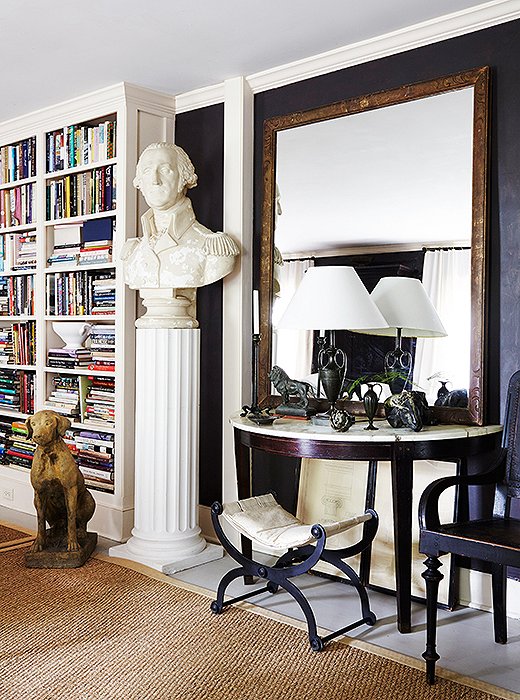 A huge bust of George Washington and an enormous framed mirror make a small room feel grand.
