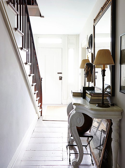 The entryway and the kitchen are painted the same pale gray (Benjamin Moore’s Nimbus), and the entry is enlivened by a playful placement of mirrors. “Mirrors are so important,” says Frank. “You get light and that sense of movement.”
