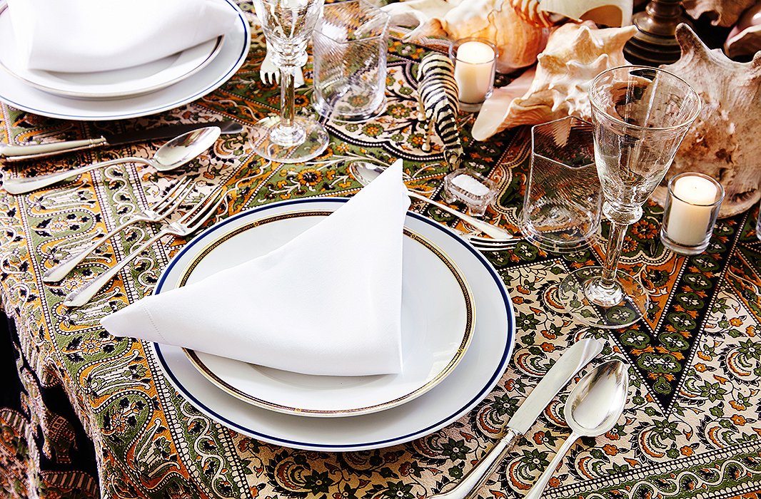 Antique glassware sparkles atop an Indian bedspread-turned-tablecloth.
