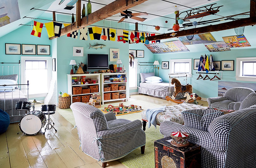 Transformed into a fantasyland playroom for Christoph and his pals, the attic room is strung with vintage signal flags that almost appear to be flapping in the sky. Twin beds and cushy upholstered pieces are sharply outfitted in a black-and-white gingham from Malabar.
