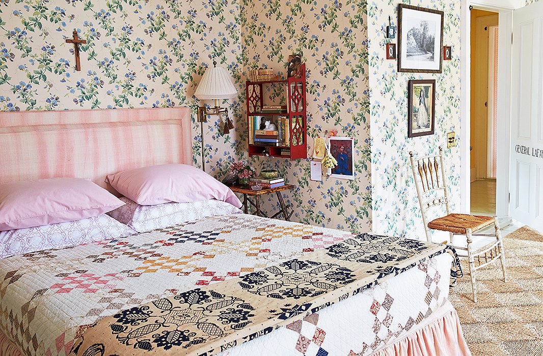 Inside General Lafayette’s bedroom (aka the ladies’ guest bedroom), sweetly trellised sweet peas crawl up the wallpaper behind a bed made with pink-and-white Sferra linens tucked cleanly under an antique quilt.
