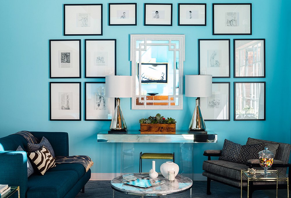 The space sticks to a limited color palette of blue, black, and white, with eye-catching mirrored surfaces, like the pair of 1960s lamps and the vintage console, and hits of wood for a bit of tonal warmth.
