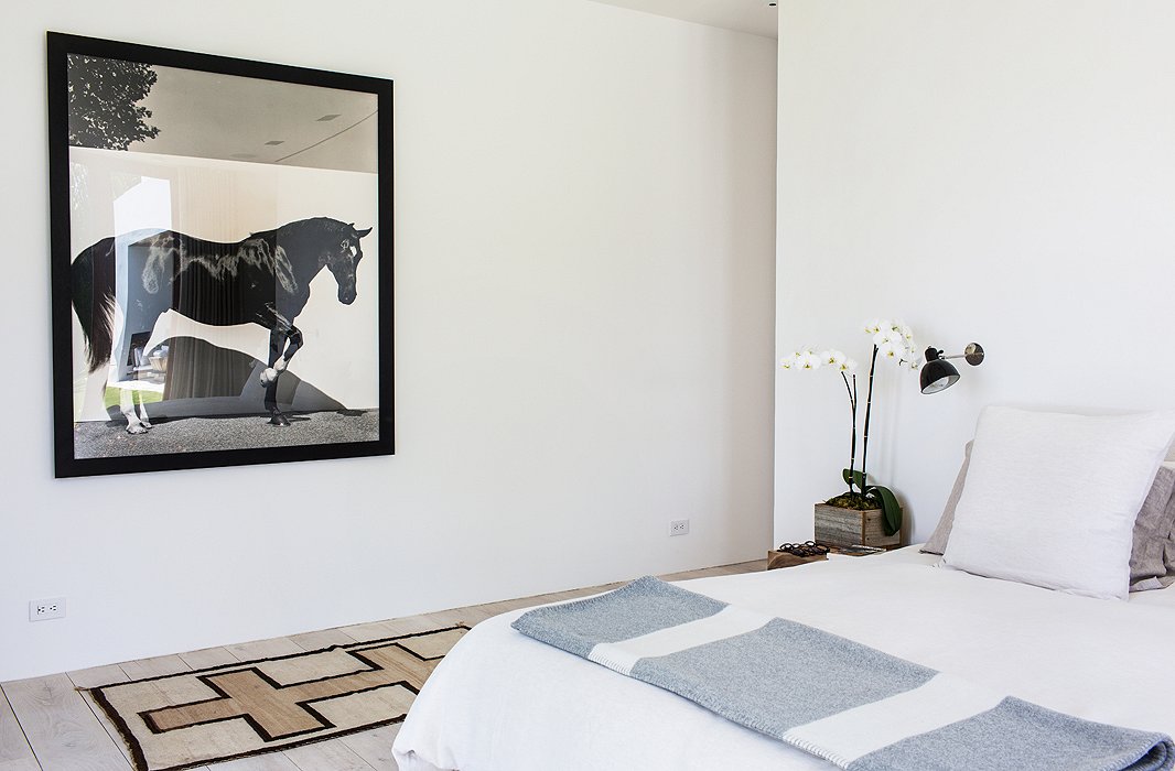 Bleached oak floors, pale walls, and matching linens make for a serene retreat. The horse photographs throughout the house, testament to Kelly’s love of horses and years of competitive riding, are by Steven Klein.
