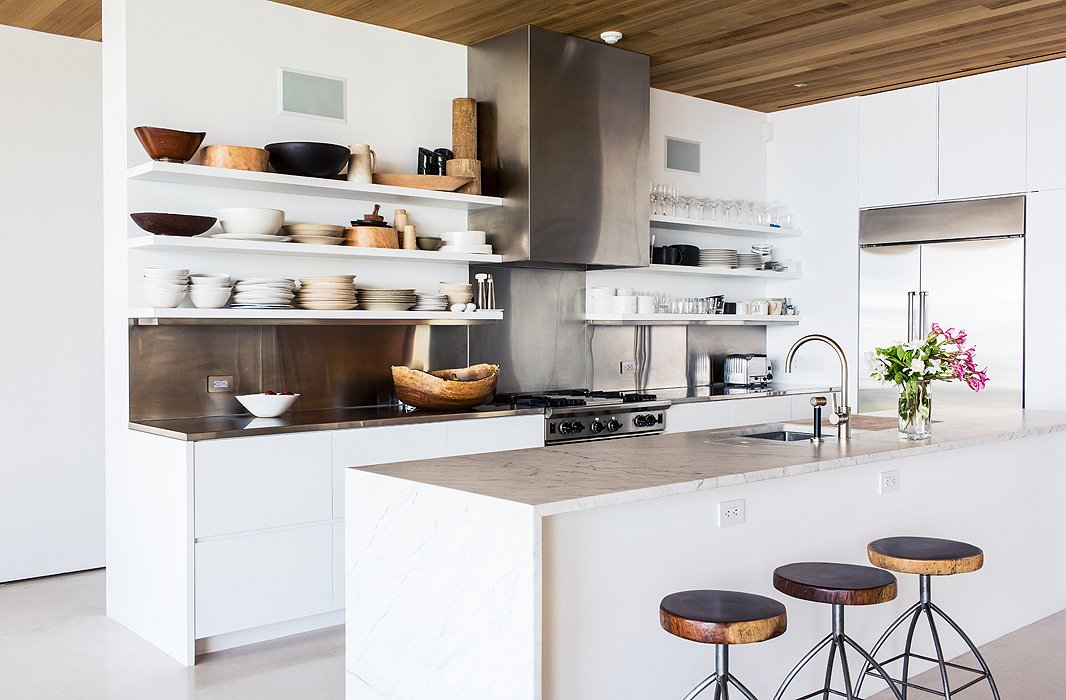 The stools were crafted by Kelly’s friend Marsia Holzer, a designer known for working with recycled woods and other natural materials; she also made the wishbone sculpture featured on an end table in the living area.
