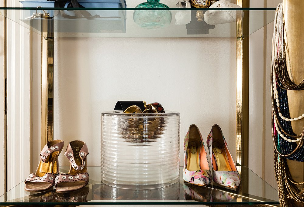 In the brass-and-glass bookcase in her bedroom, Kim mixed things up by displaying her shoes, letting her current favorites share shelf space with personal photos and frequently worn jewelry.
