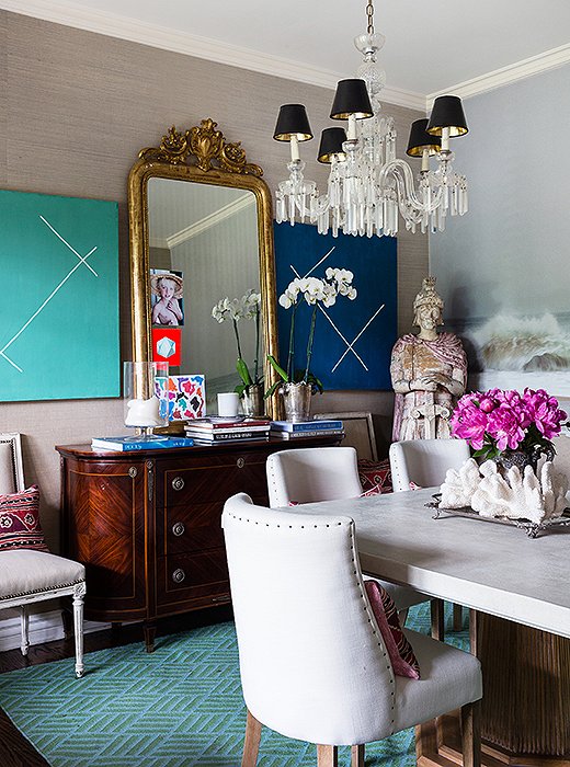 The paintings in the dining room are by Andrew Gellatly, the mirror is an Italian family heirloom, and the sideboard comes from One Kings Lane.
