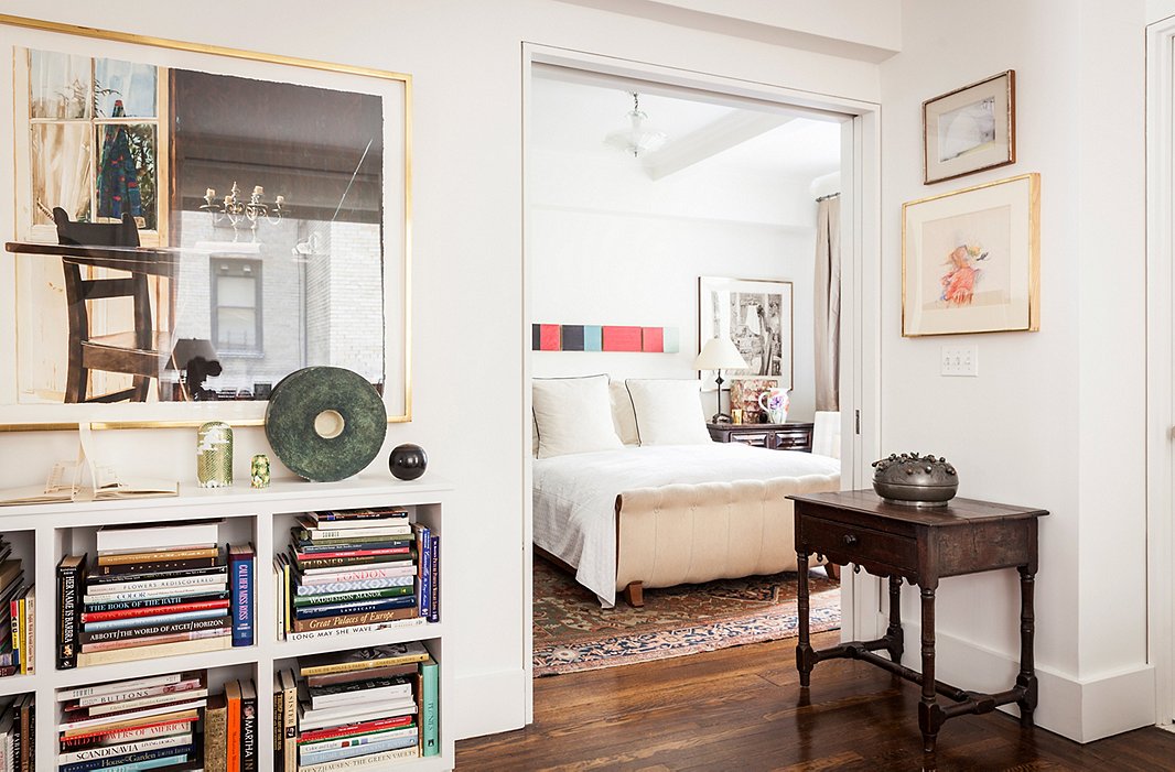 A pale bed and walls let artwork shine. Hanging over the bed (the Calla, designed by Mariette for Hickory Chair) is a set of paintings by Yuko Shiraishi; outside the door hangs a watercolor by Carolyn Brady.
