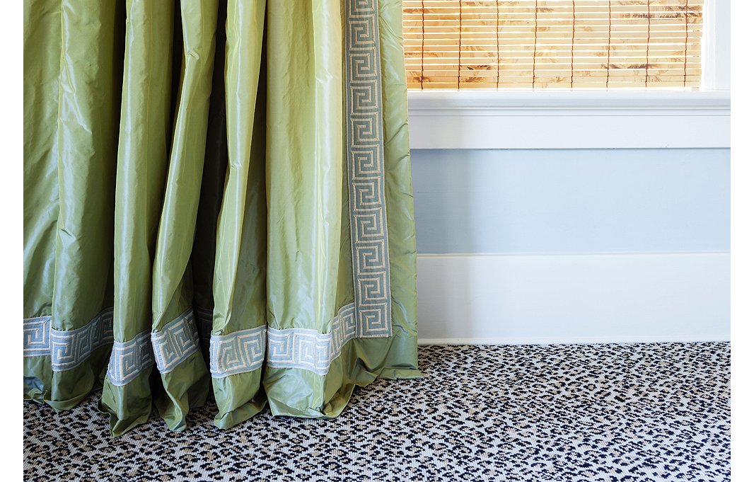 The green taffeta curtains with Greek key trim display the one-inch break that Megan swears by. Their juxtaposition against the leopard carpet is one of her favorite moments in the house.
